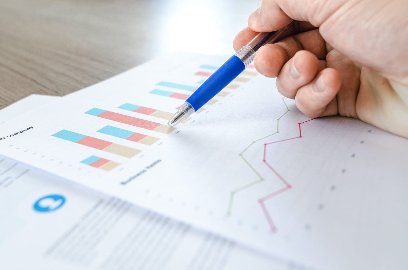 A person, who is a statistics student, is holding a pen and writing on a piece of paper with specific allocations for statistical analysis.