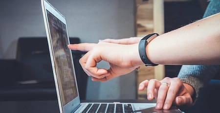 Student pointing to laptop screen seeking online term paper help