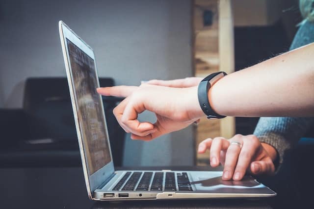 Student pointing to laptop screen seeking online term paper help